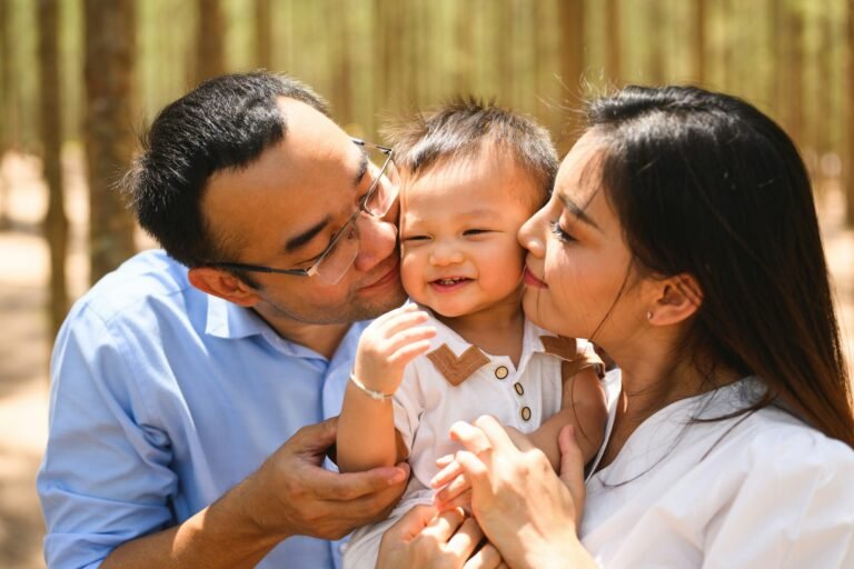 Sleep - Loving parents and baby embracing and kissing on cheek at park