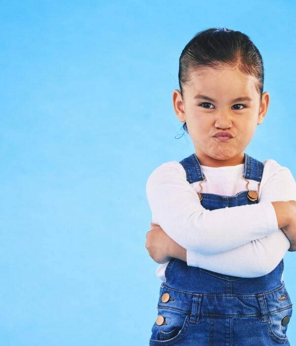 Angry, child and arms crossed with tantrum in studio with mockup space. Kid, young girl and frustra