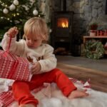 Caucasian toddler unpacking Christmas present