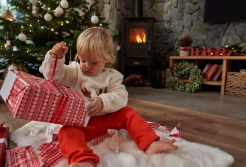 Caucasian toddler unpacking Christmas present