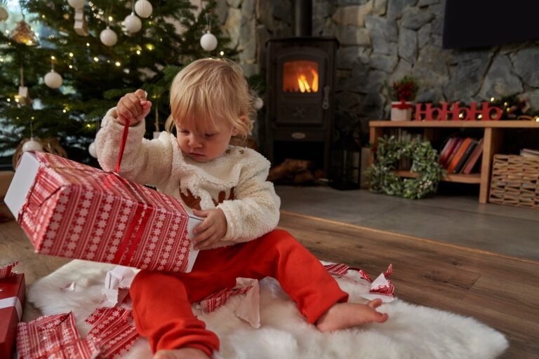 Caucasian toddler unpacking Christmas present