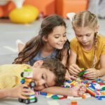 Kids playing with toys on the floor.