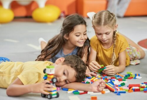 Kids playing with toys on the floor.