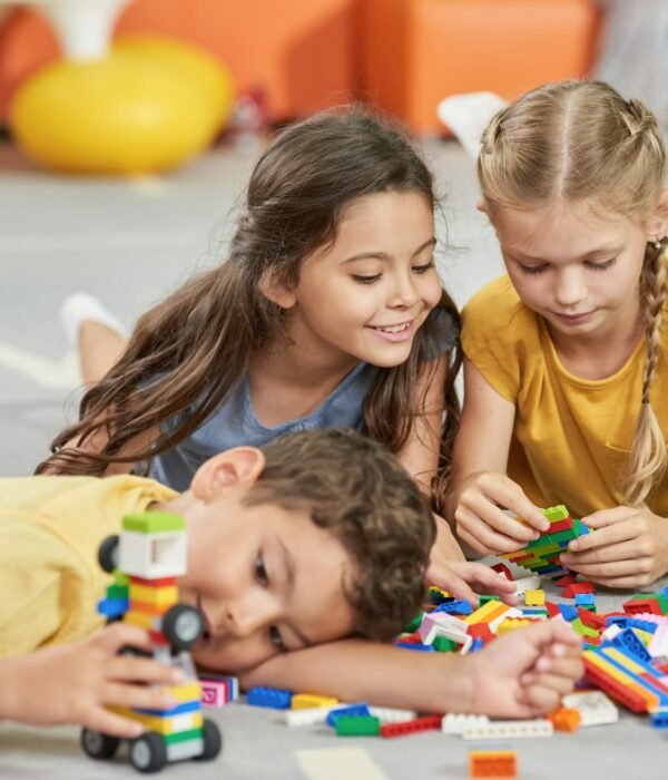 Kids playing with toys on the floor.