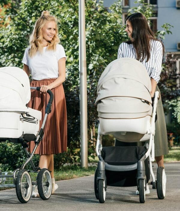 mothers walking with baby strollers on street