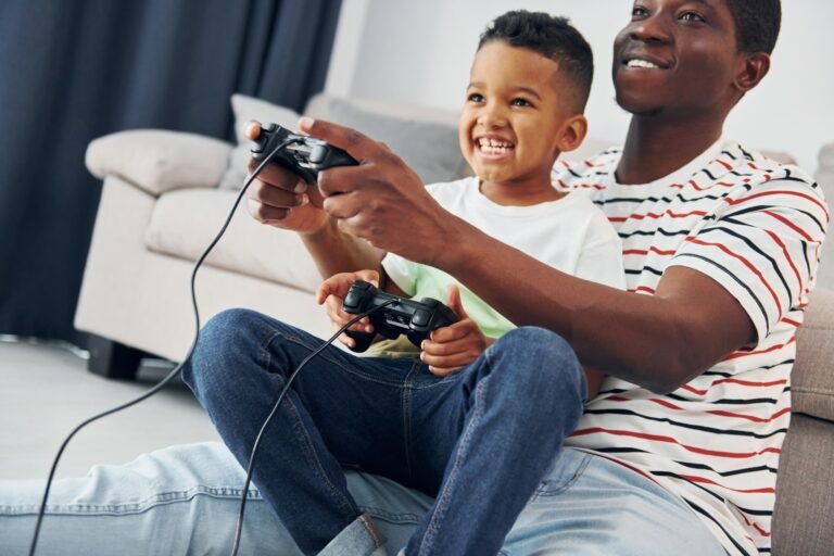 Playing video games. African american father with his young son at home